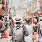 Young man hipster traveling with backpack and hat, happy Solo traveler walking at Chinatown street market in Singapore. landmark and popular for tourist attractions. Southeast Asia Travel concept
